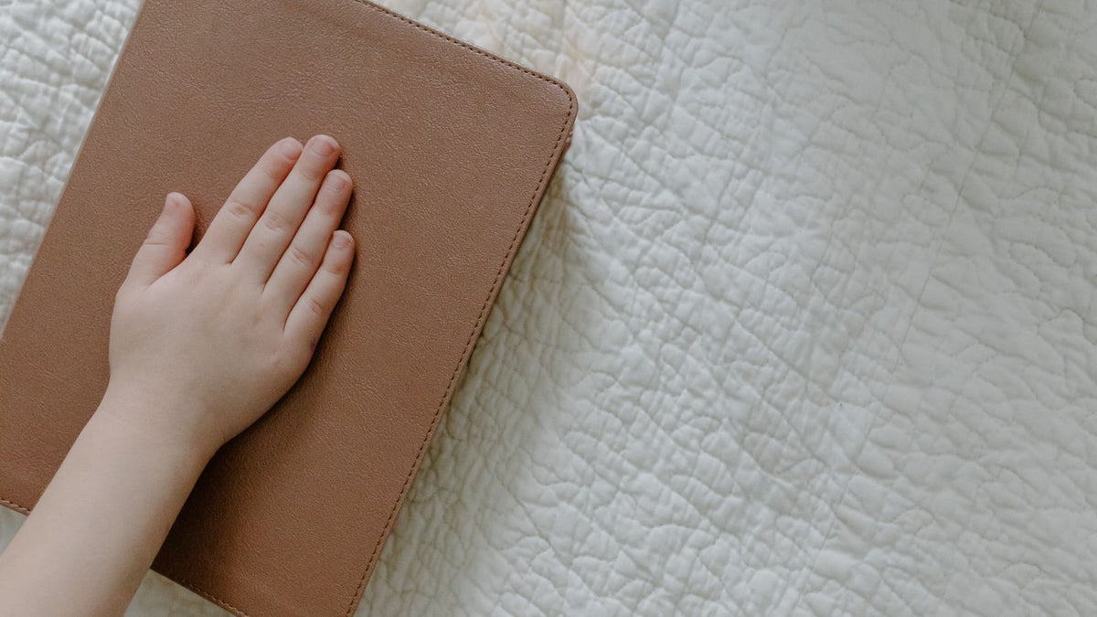 Main posée sur le tissu matelassé d'une couverture lestée