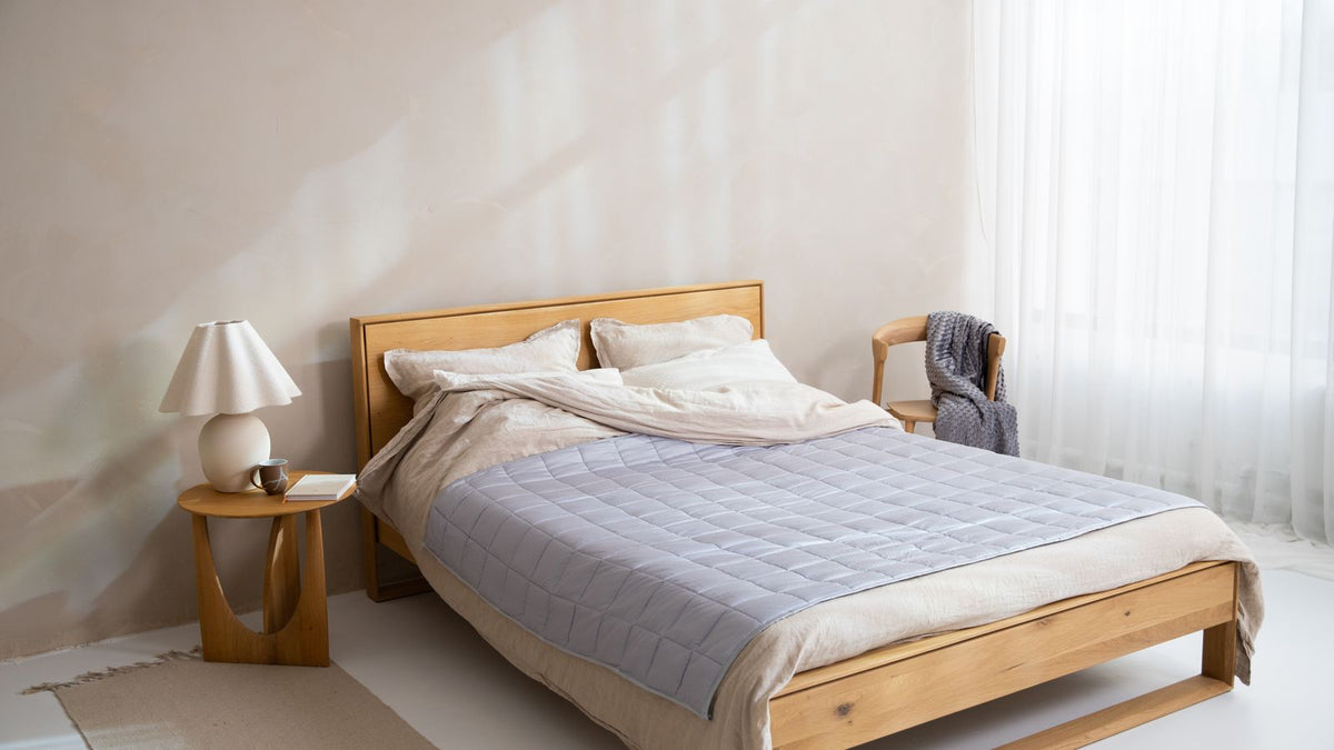 Couverture lestée posée sur un lit dans une chambre chaleureuse