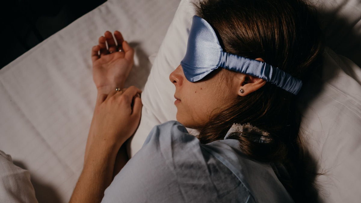 Personne allongée de dos avec un masque de sommeil sur les yeux