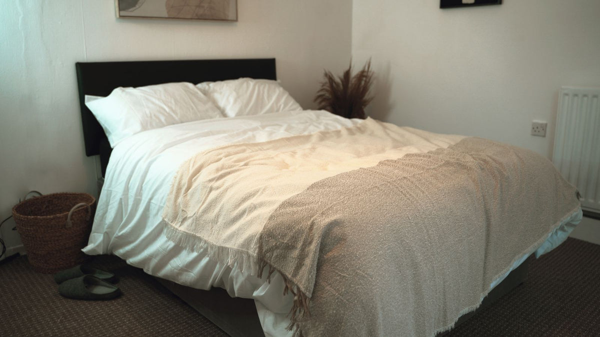 Couverture lestée posée sur un lit double fait avec soin